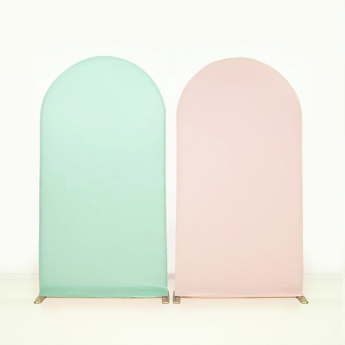 Two vertical stretchable arch backdrop covers in mint green and blush pink.