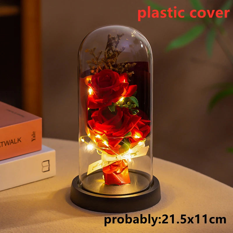 A glass dome containing an LED galaxy rose artificial flower displayed on a black base.