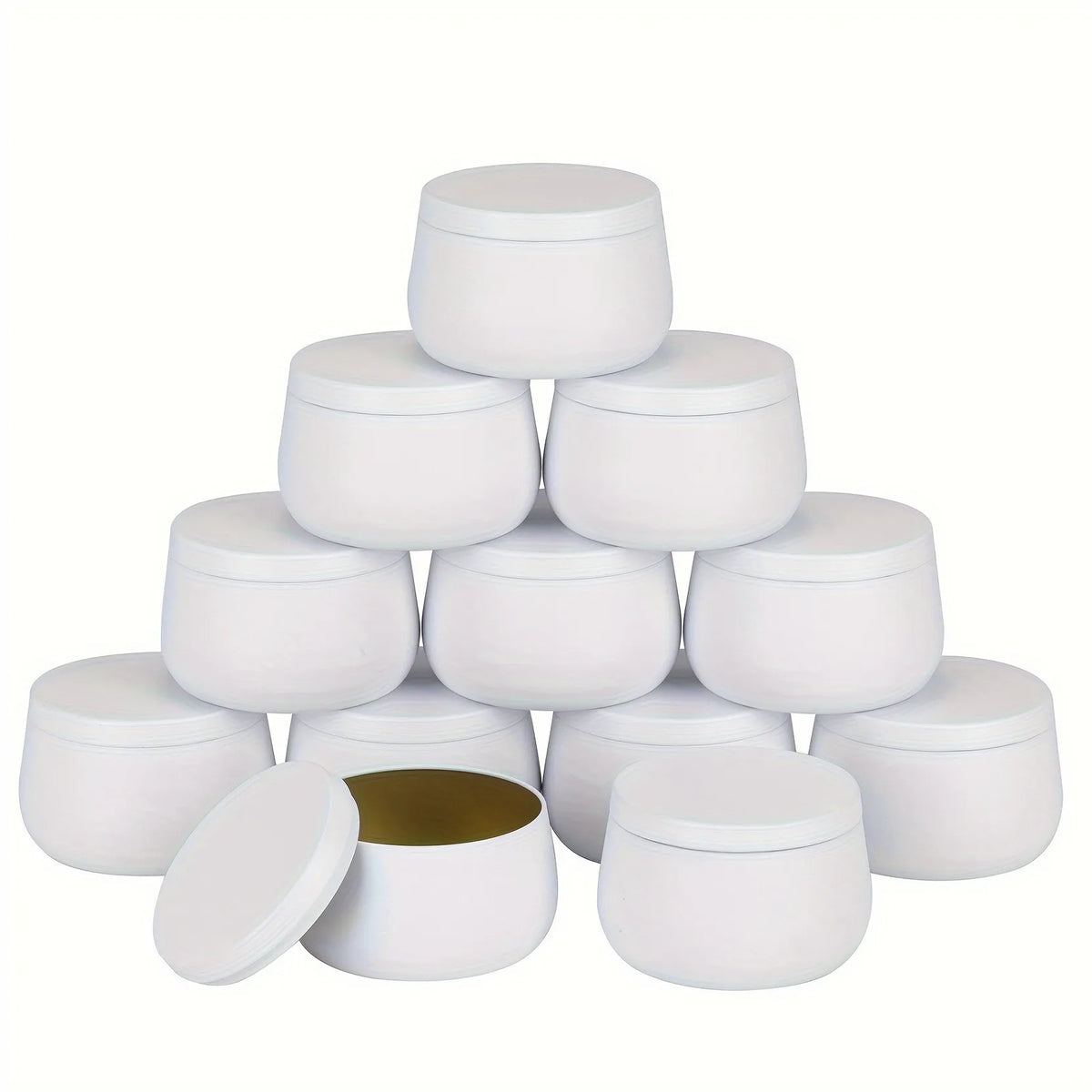 A set of white metal candle tins with lids arranged in a pyramid formation.