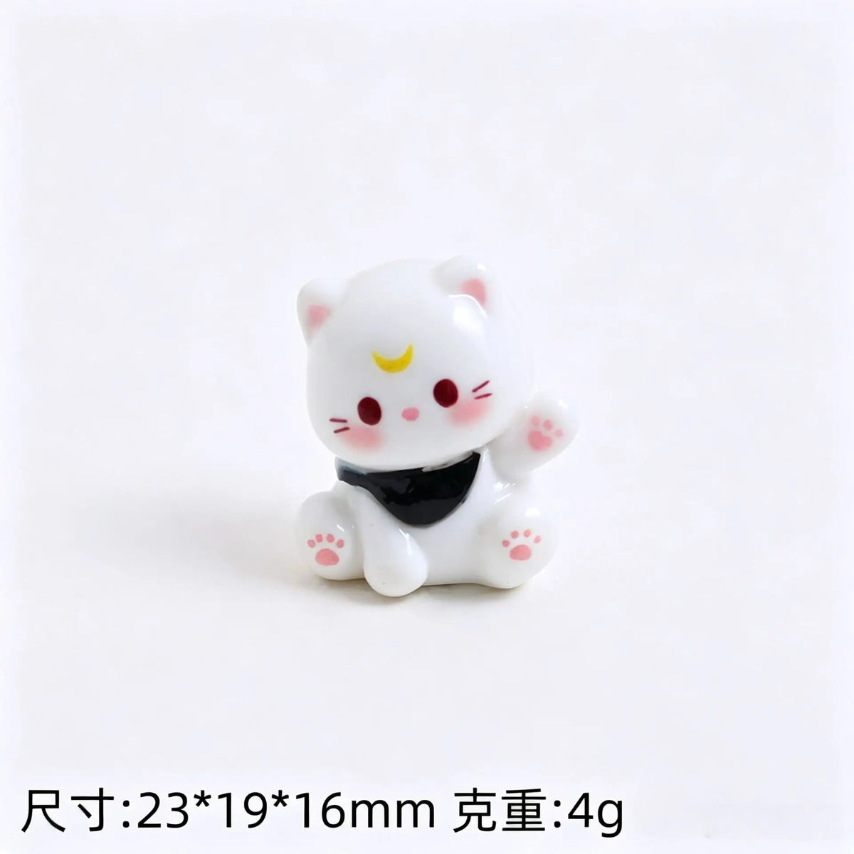 A small white resin cat keychain with pink accents and a black collar.
