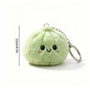 A light green plush butter dumpling squishy keychain with a smiling face and silver keyring.