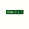 A rectangular green metal sign with the word COWBOY and the letters DR on it.