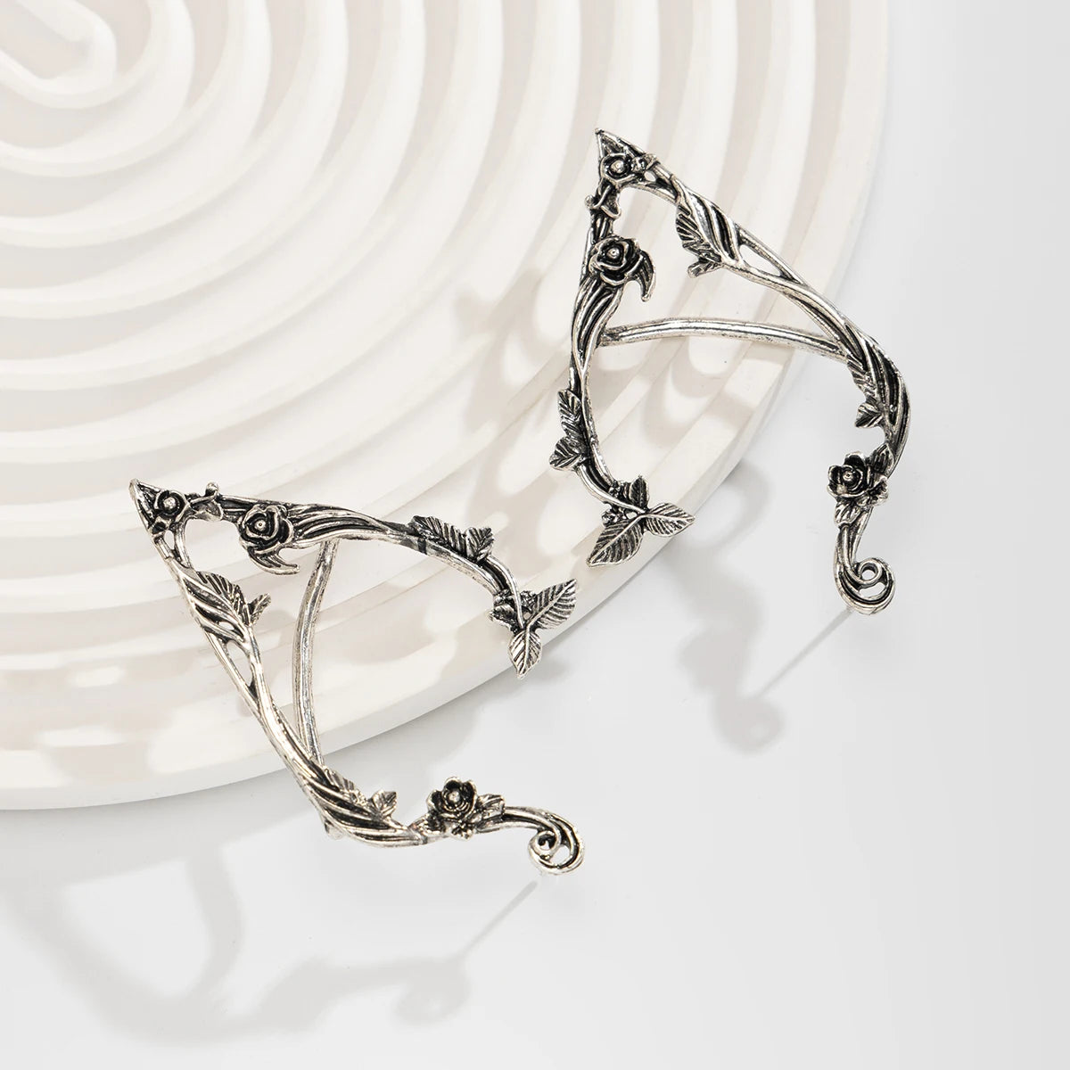 Silver elf flower leaf clip earrings displayed on a light background.