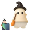 A cute ghost phone decoration charm with a black witch hat and a wooden broomstick.