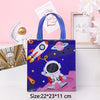 A dark blue non-woven tote bag featuring a space theme design with rockets and planets, displayed next to a golden figurine.