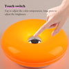 Hand justiert die Helligkeit einer orangen, donutförmigen, wiederaufladbaren Wandlampe mit einem Touchschalter.