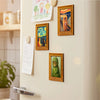 A collection of framed fridge magnets featuring Van Gogh's starry sky and cat paintings on a light-colored wall.