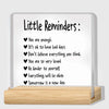 A clear acrylic desk plaque with black text listing little reminders such as You are enough and Everything will be okay.