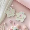 Light pink background featuring wooden milestone cards marked 1 month and 3 months with small flowers