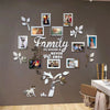 A wall decorated with a family tree photo collage featuring various framed pictures and leafy silhouettes.