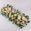 A lush floral arrangement featuring white, cream, and peach roses and greenery for event decor.