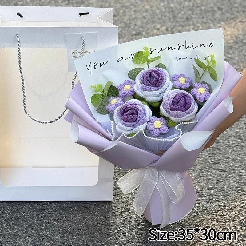 A handmade crochet flower bouquet featuring purple and yellow flowers wrapped in lilac paper.