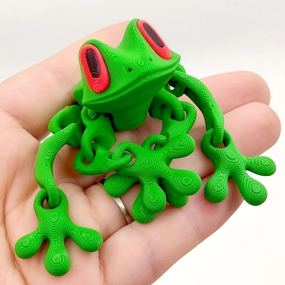 A bright green, realistic frog figurine with red eyes is held in a hand.