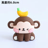 A cute, stylized monkey decoration with a yellow banana on its head, used for birthday decorations.