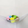 A mesh storage hammock holds various colorful stuffed animals and toys against a white wall.