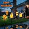 Une rangée de lumières en forme de citrouille et de crâne illuminent une scène de jardin pour la décoration d'Halloween.