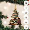 Ornement en forme d'arbre de livres décoratif avec une étoile dorée, suspendu à une branche de sapin de Noël.