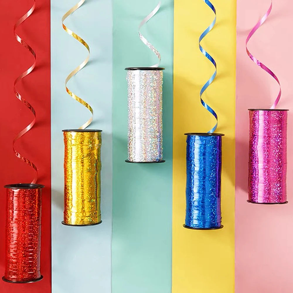 A vertical display of various colored glitter curling ribbon rolls in red, gold, silver, blue, and pink.