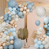 A floral arrangement of latex balloons in blue, sand, white, and gold forming a wreath display.
