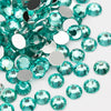 A close-up view of various round flatback resin rhinestones in shades of teal and aqua.