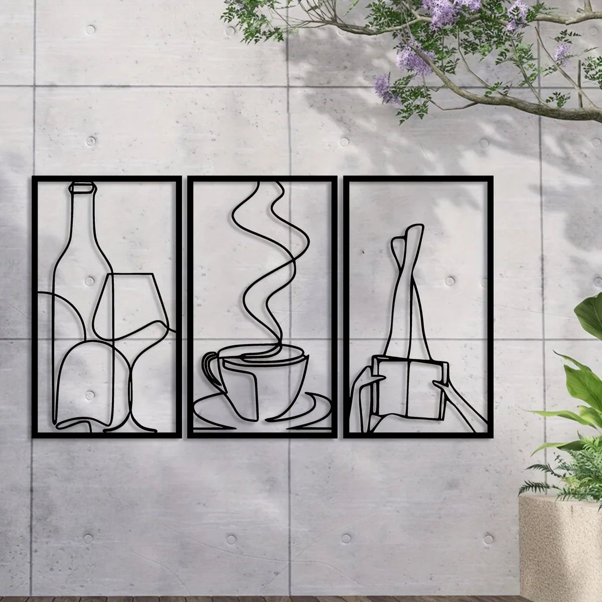 Three minimalist line art prints of a bottle, a glass, and a cup on a gray concrete wall.