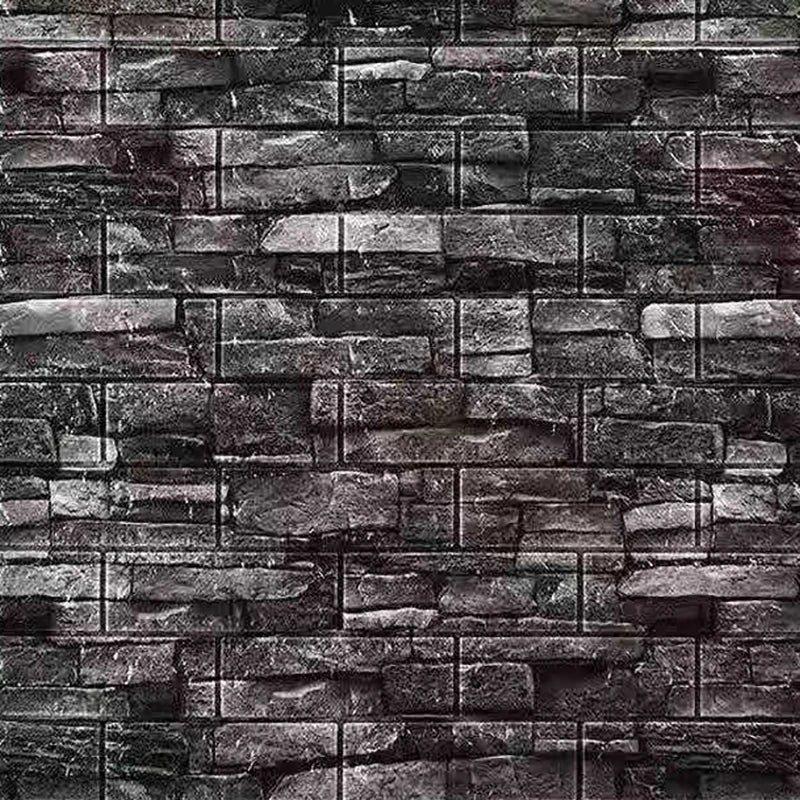 A close-up texture of dark gray and black stacked stone or brick wall panels.