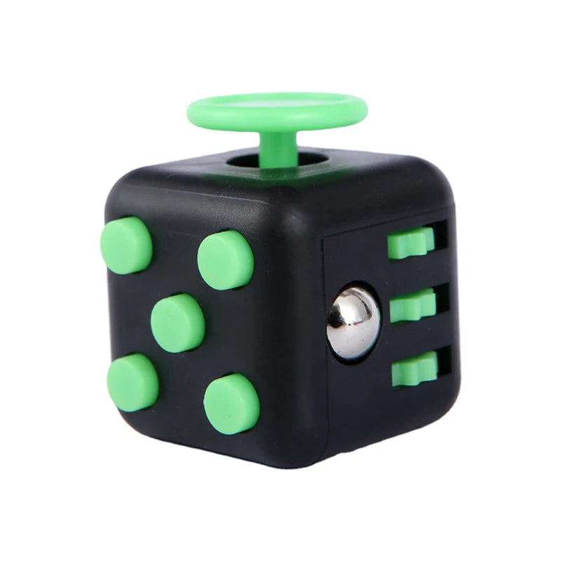A black fidget cube with light green dots and a green top, used as a stress relief toy.