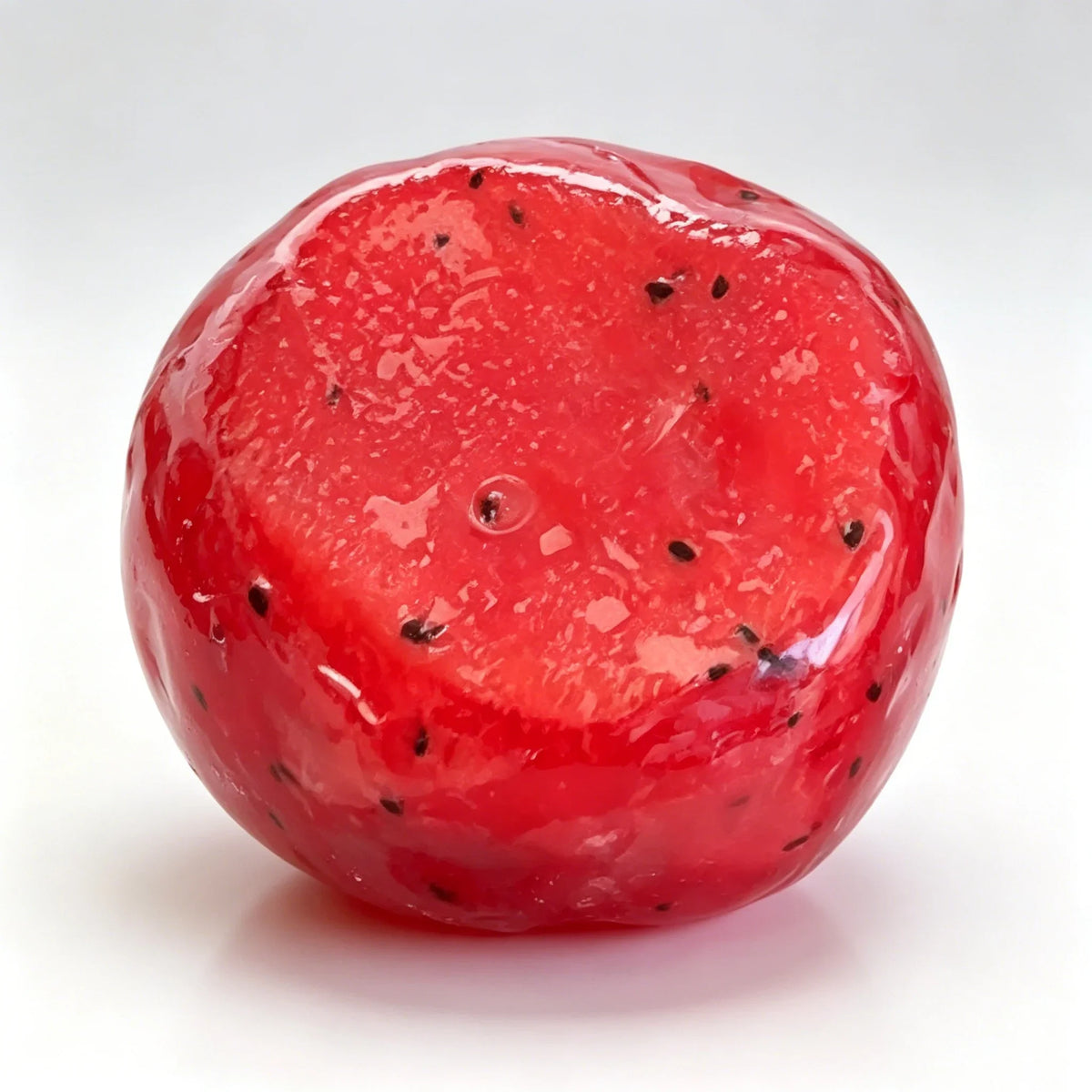 A bright red, translucent watermelon-shaped squishy fidget toy with black seeds.