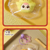 A yellow egg tart shaped squeeze toy keychain is displayed on a light yellow tray.