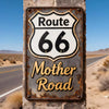 Vintage tin sign for Route 66 Mother Road mounted on a rustic stone wall in a desert landscape.