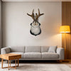 A decorative wall mount featuring a taxidermy bunny head with antlers mounted on a light gray sofa in a modern living room.