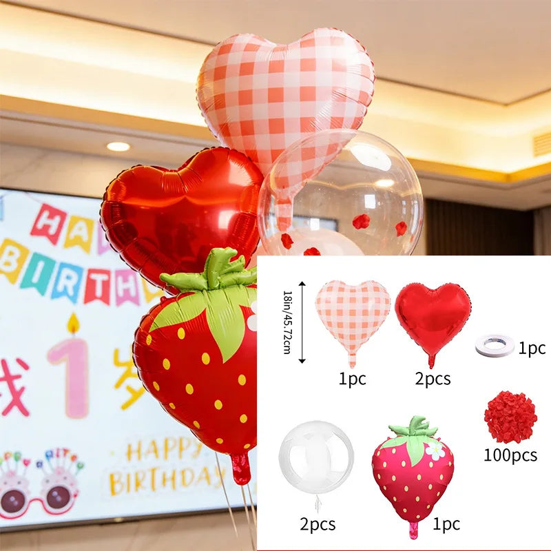 A set of strawberry theme birthday decorations including a banner, heart-shaped balloons, and honeycomb ornaments.