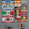 A collection of vintage metal tin signs featuring various countries and cities mounted on a gray wall.