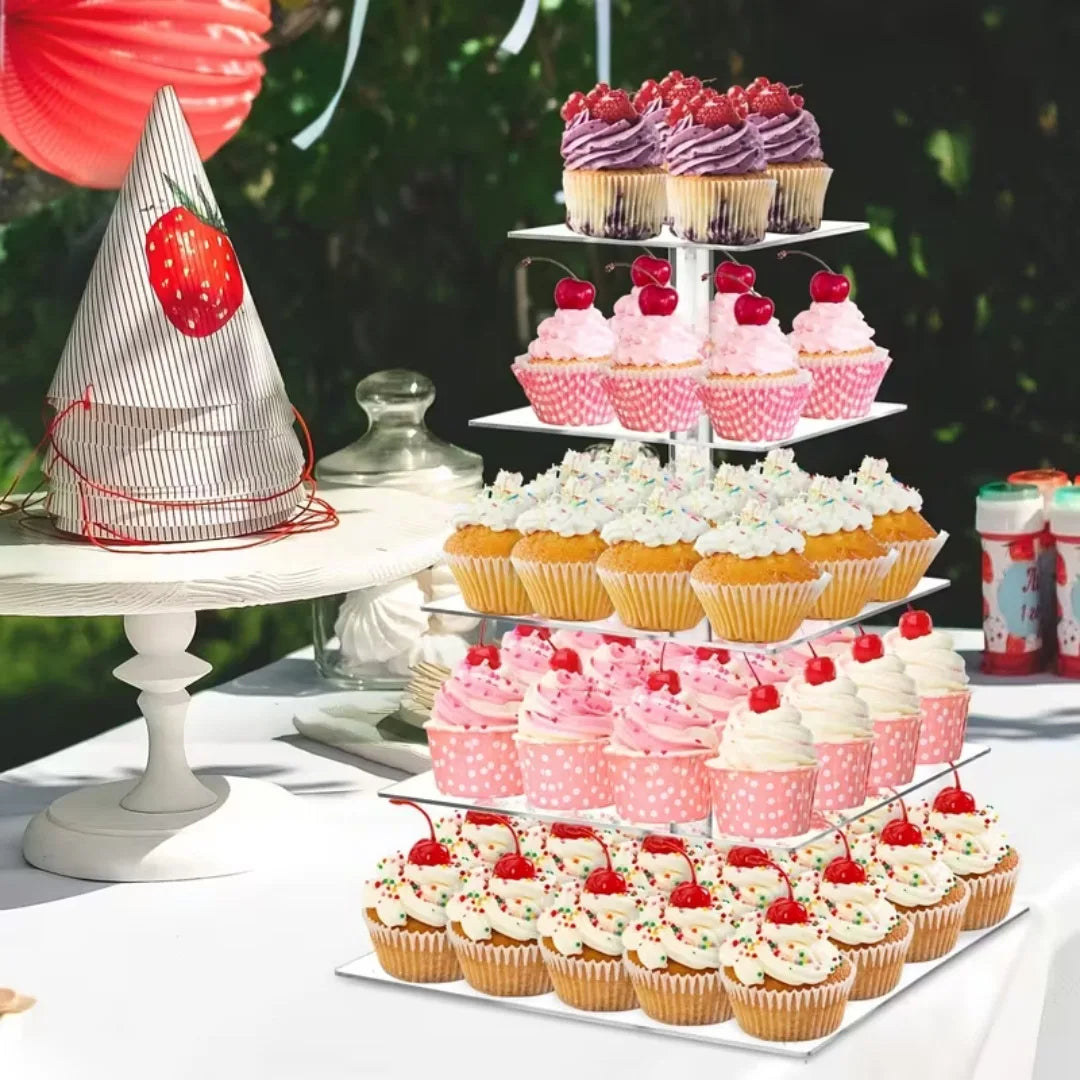 A tiered stand displaying various pink and red cupcakes with cream frosting and fresh berries.