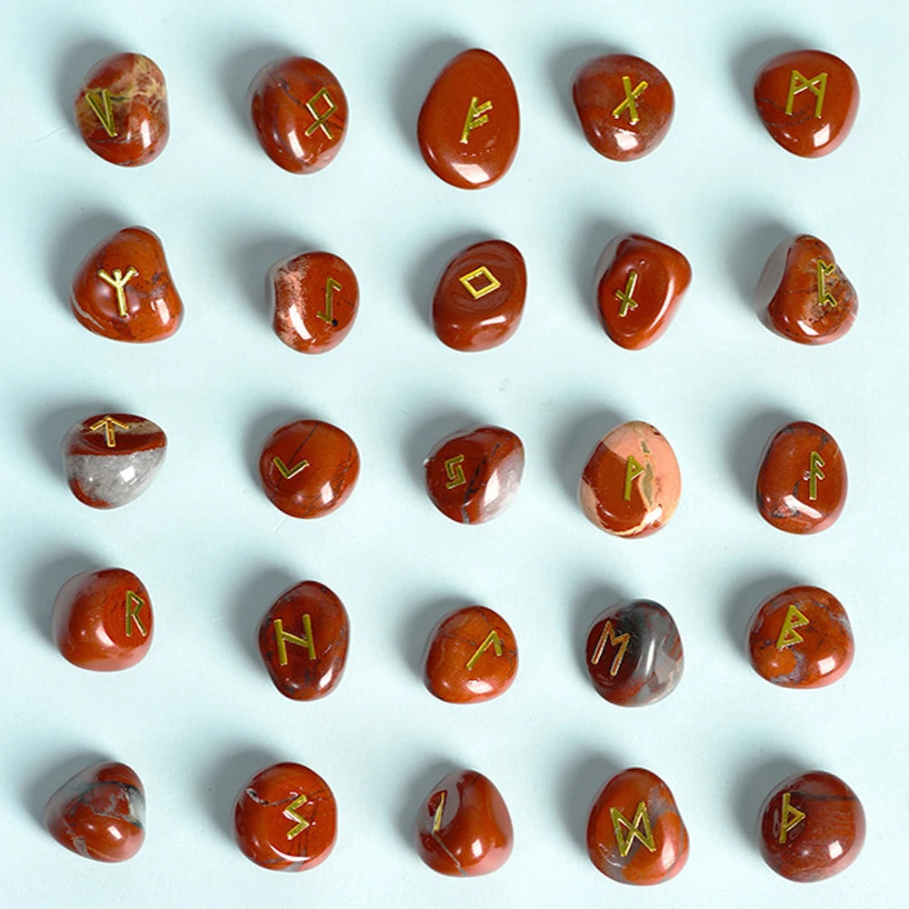Colección de 25 piedras rúnicas de cristal natural en tonos naranja-rojizo y marrón, dispuestas sobre un fondo gris claro