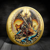 A gold-plated collectible coin featuring an Archangel Michael with large feathered wings.