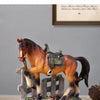 A detailed rustic western horse sculpture with a saddle and bridle displayed on a wooden base.