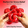 Hands hold a bright red watermelon slushy squishy fidget toy showing its soft and squishy texture.