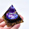 A dark purple and gold crystal pyramid featuring a large amethyst sphere and zodiac sign engravings.