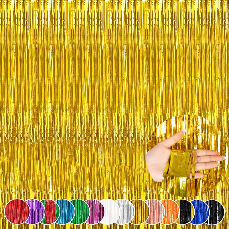 A hand is holding a gold metallic tinsel foil fringe curtain backdrop for parties against a shimmering gold background.