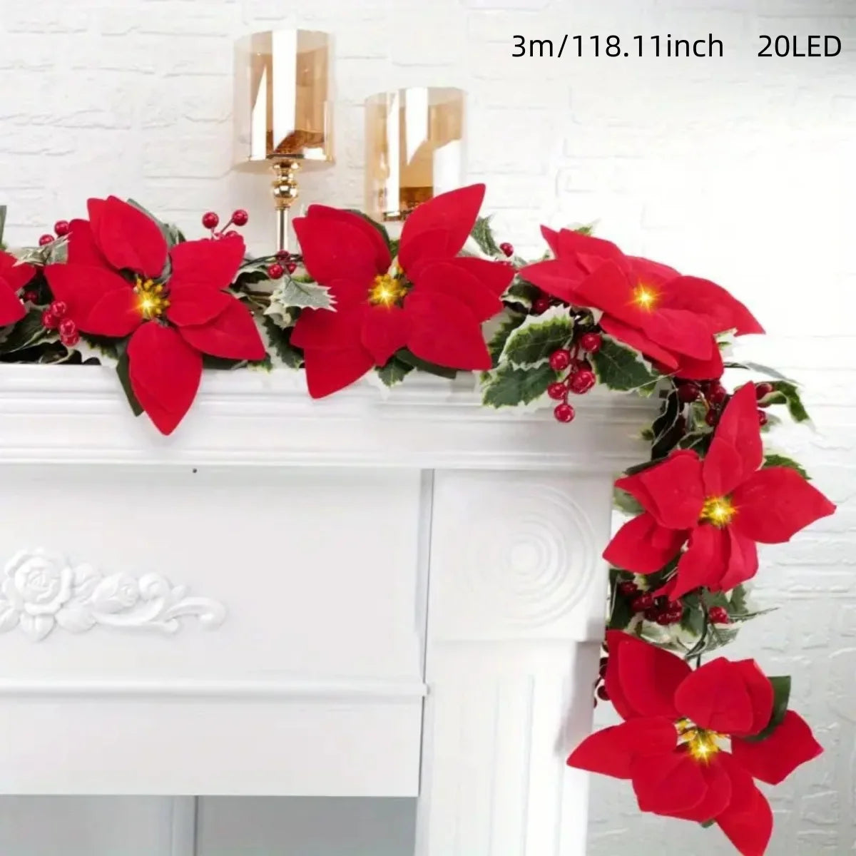 A garland of red poinsettia flowers and greenery displayed on a white mantelpiece.