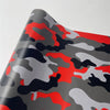 A close-up of a color-changing digital camouflage vinyl wrap film featuring red, black, and gray patterns.