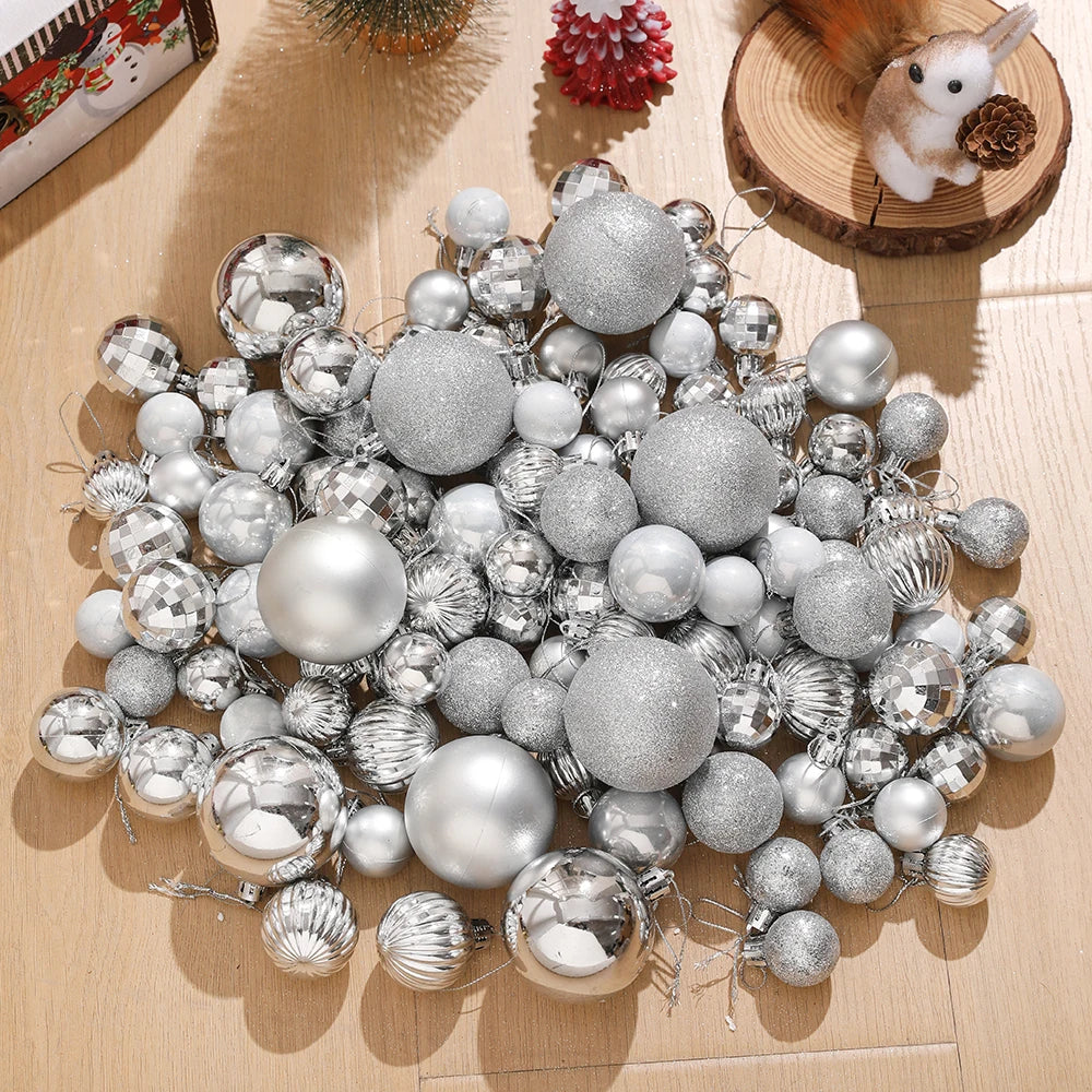 A collection of silver and gold spherical Christmas tree ornaments scattered on a light wooden surface.
