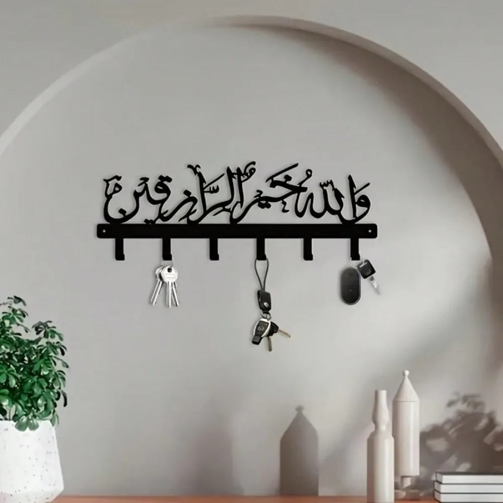 Islamic Arabic blessing key holder with hooks mounted on a white wall.