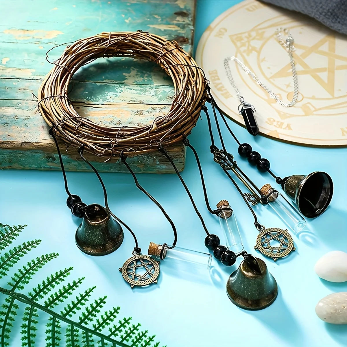 A vintage wicker wreath of thin branches with hanging brass and glass bells on dark cords.