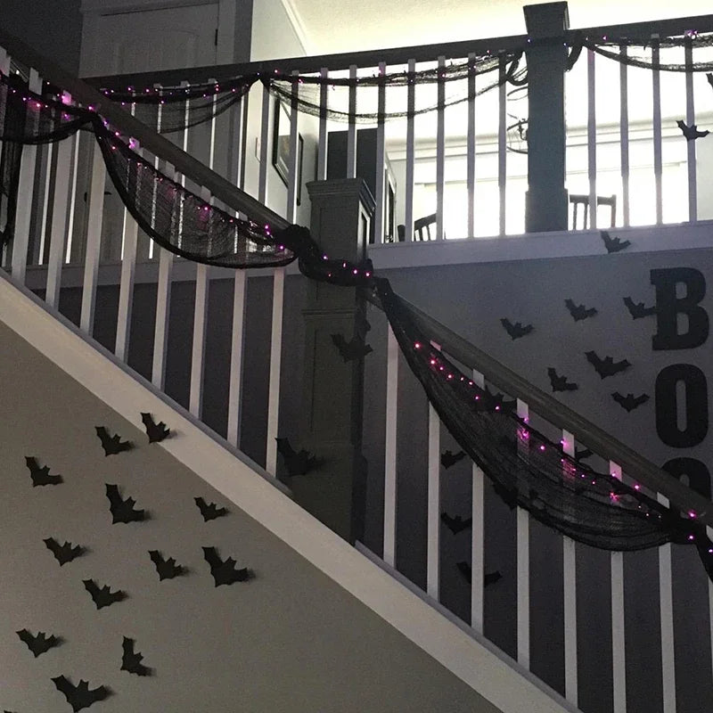 Black gauze netting draped across a balcony railing for spooky party decor