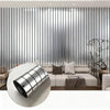 A round, silver self-adhesive mirror effect wallpaper is displayed against a modern interior wall with vertical metal slats.