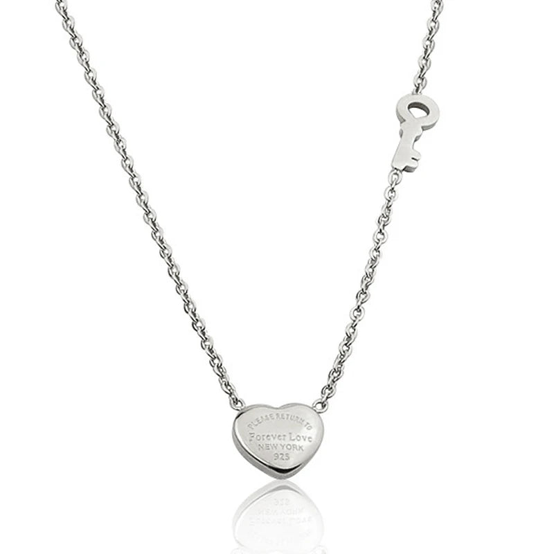A silver titanium steel heart lock key pendant necklace displayed against a white background.