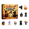 Halloween mystery box featuring various spooky resin figurines and a carved pumpkin.