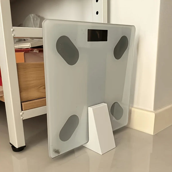 A clear floor stand for a body fat scale with several oval cutouts on the surface.
